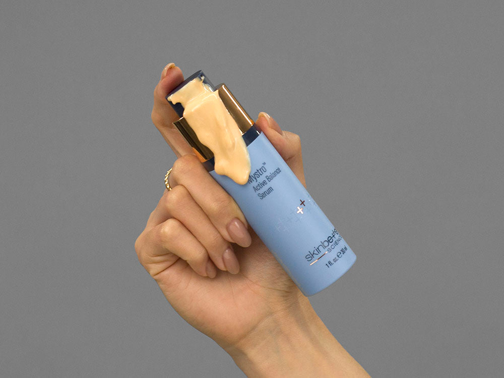 Closeup of Laziza from LAZ Skincare holding up a bottle of SkinBetter Science Mystro Active Balance Serum