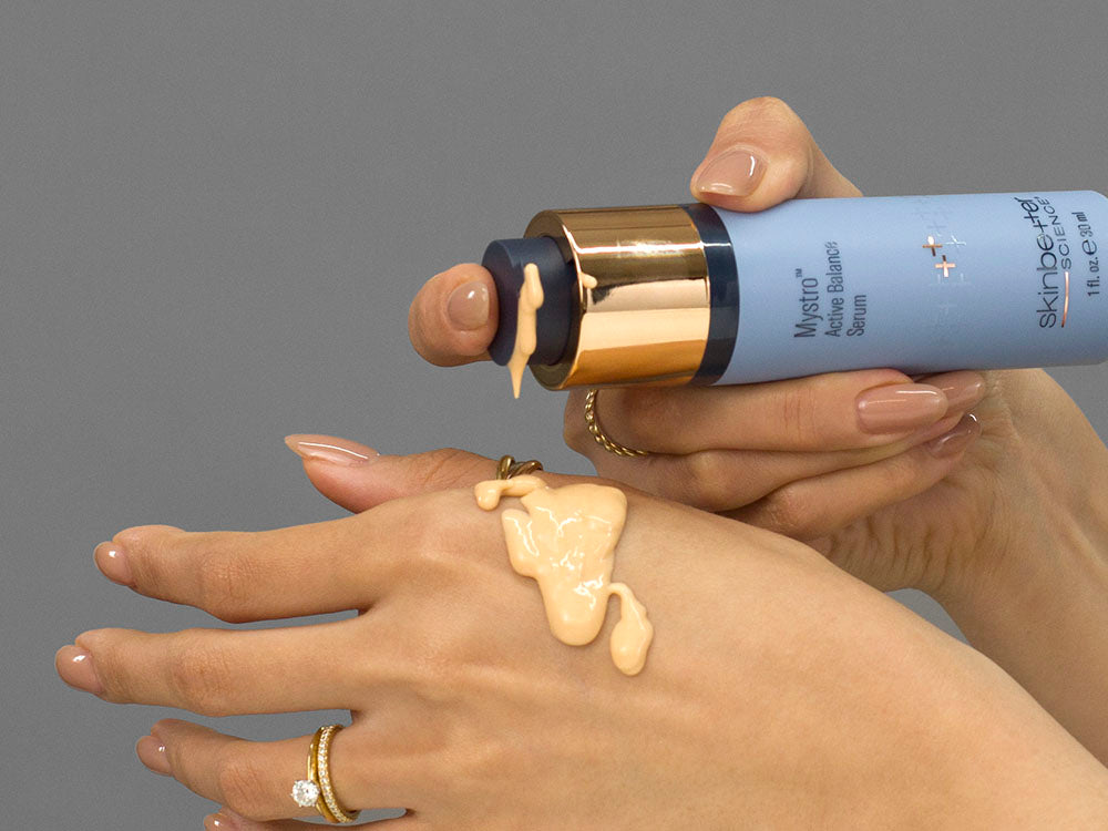 Closeup of Laziza from LAZ Skincare holding up a bottle of SkinBetter Science Better Balance Duo