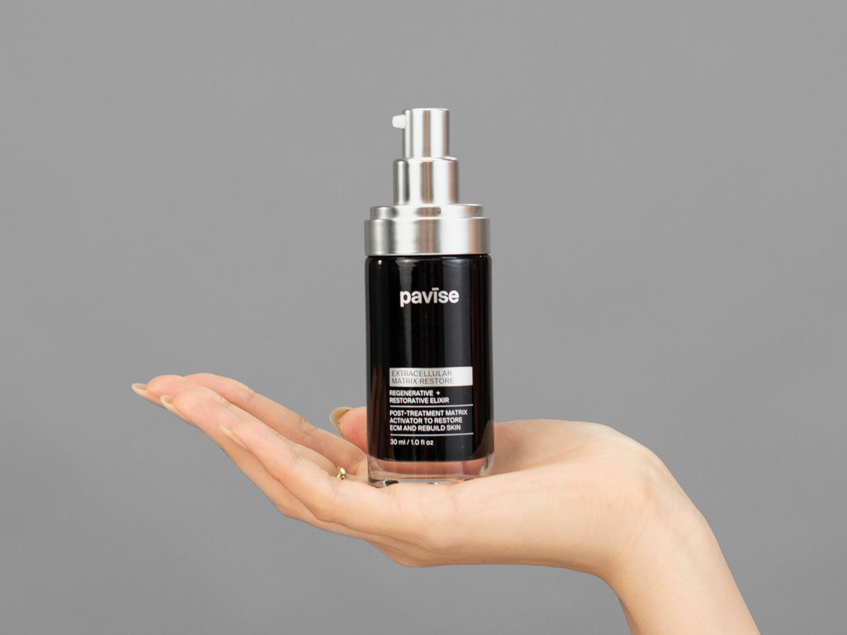 Closeup of Laziza from LAZ Skincare holding up a bottle of Pavise Extracellular Matrix Restore