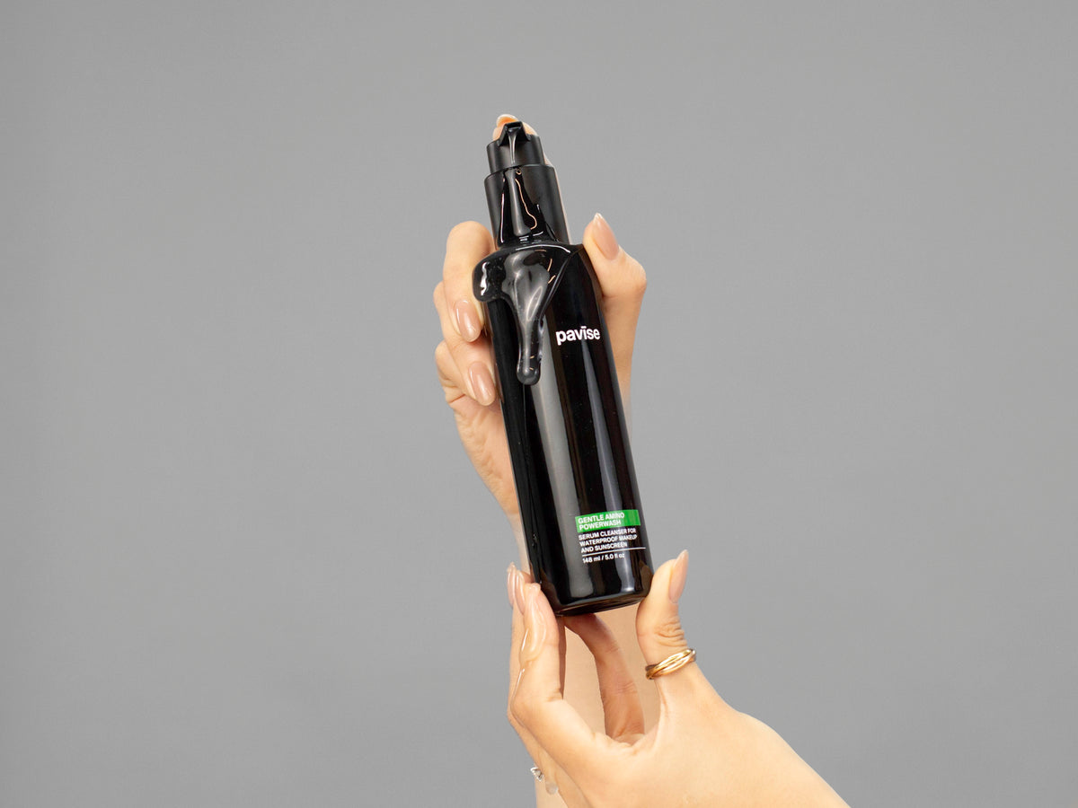 Closeup of Laziza from LAZ Skincare holding up a bottle of Pavise Gentle Amino Powerwash