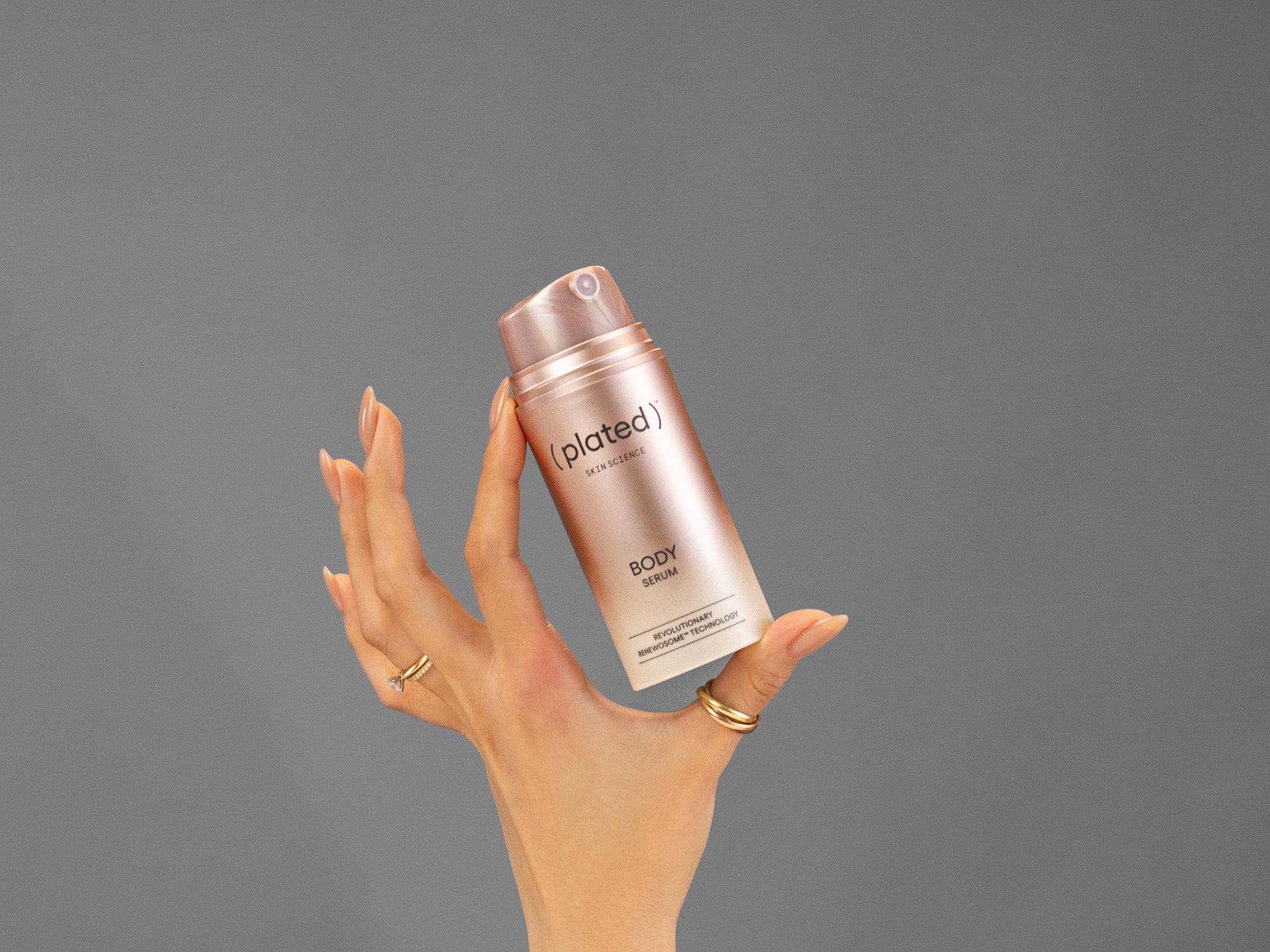 Closeup of Laziza from LAZ Skincare holding up a bottle of Plated Body Serum