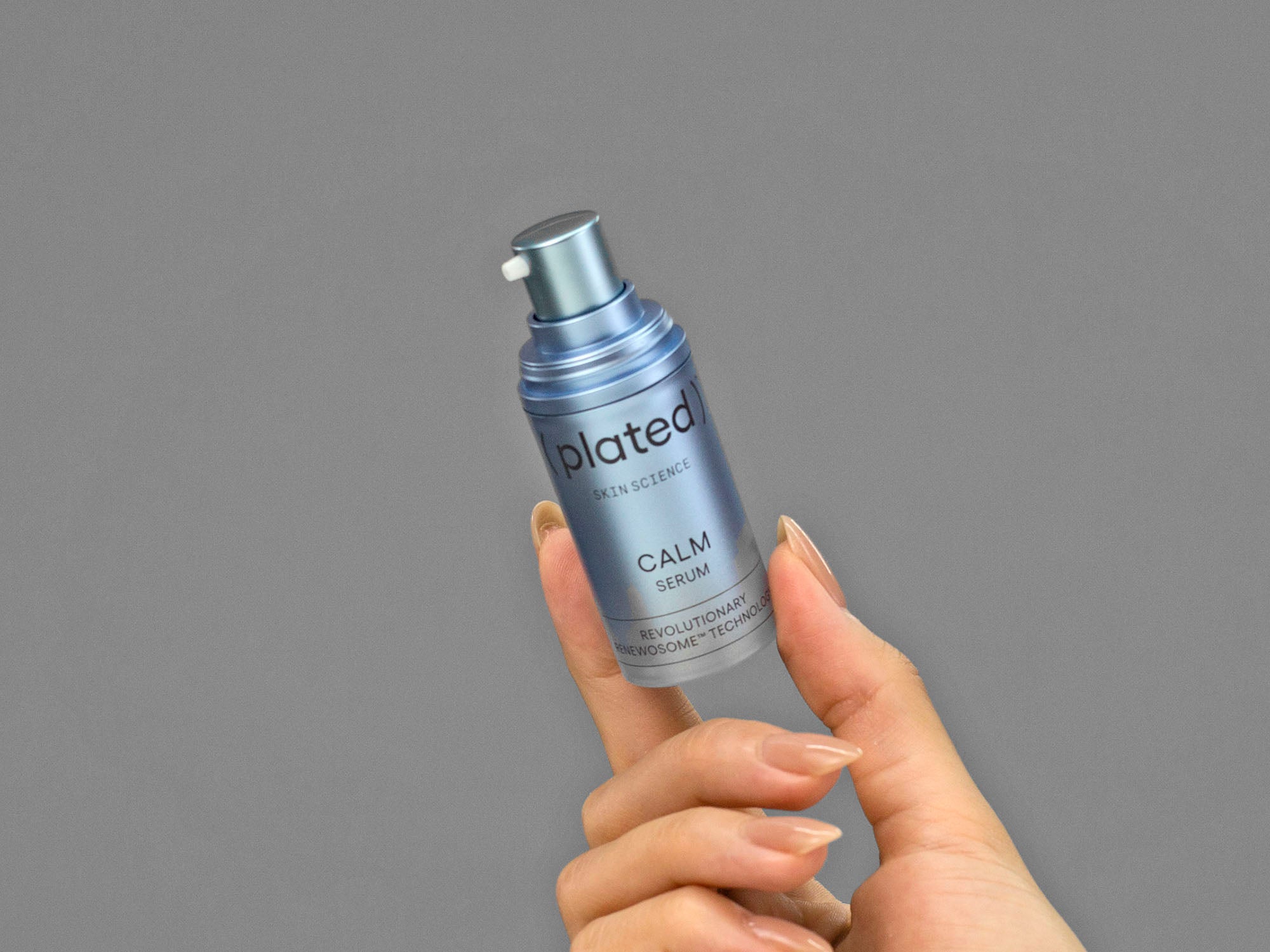 Closeup of Laziza from LAZ Skincare holding a bottle of Plated Calm Serum in her hand