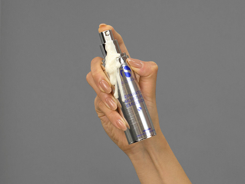 Closeup of Laziza from LAZ Skincare holding up a bottle of iS Clinical Reparative Moisture Emulsion