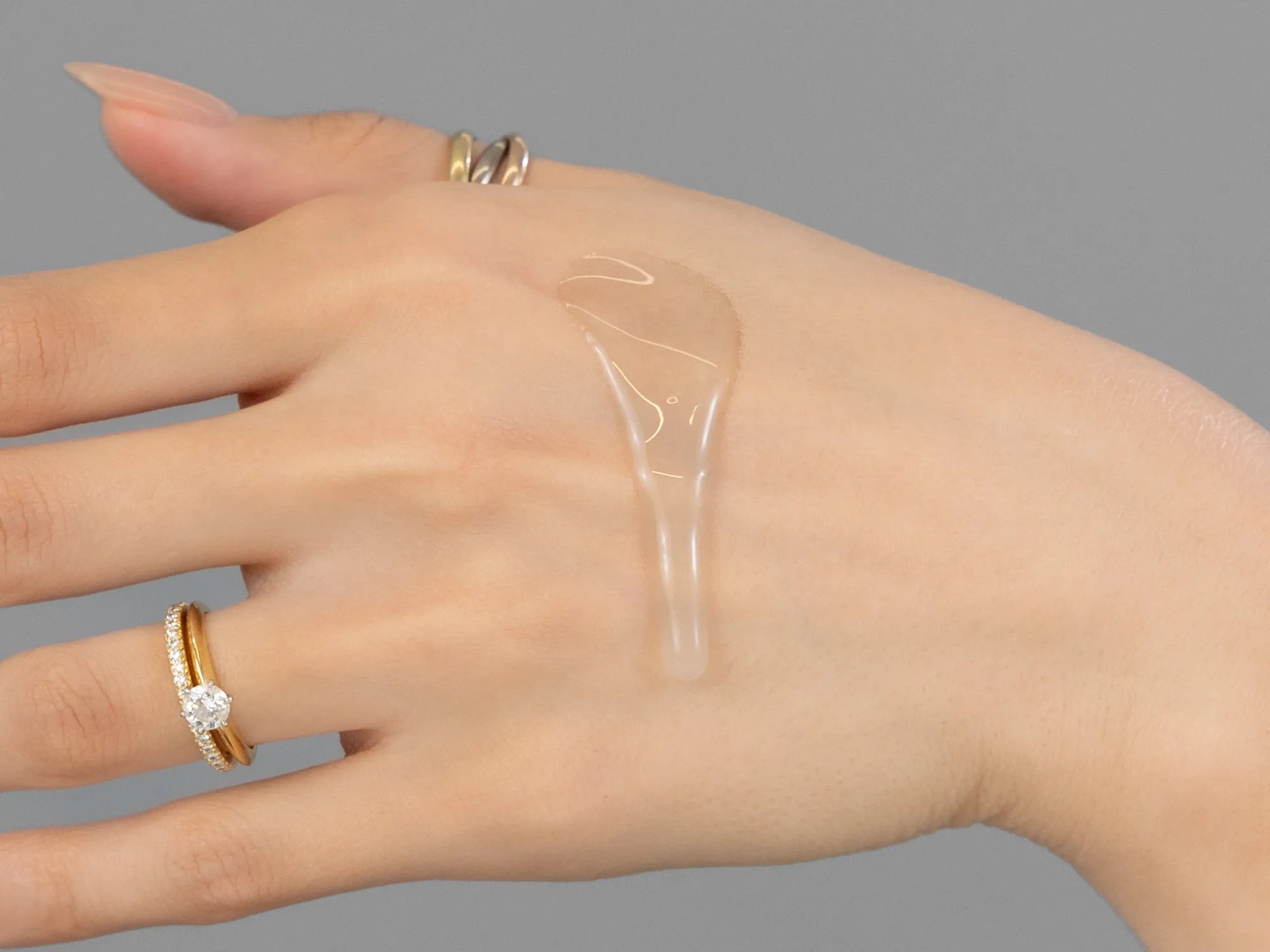 Laziza from LAZ Skincare demonstrating the texture and application of Revision HA HydraSerum+ on her hand