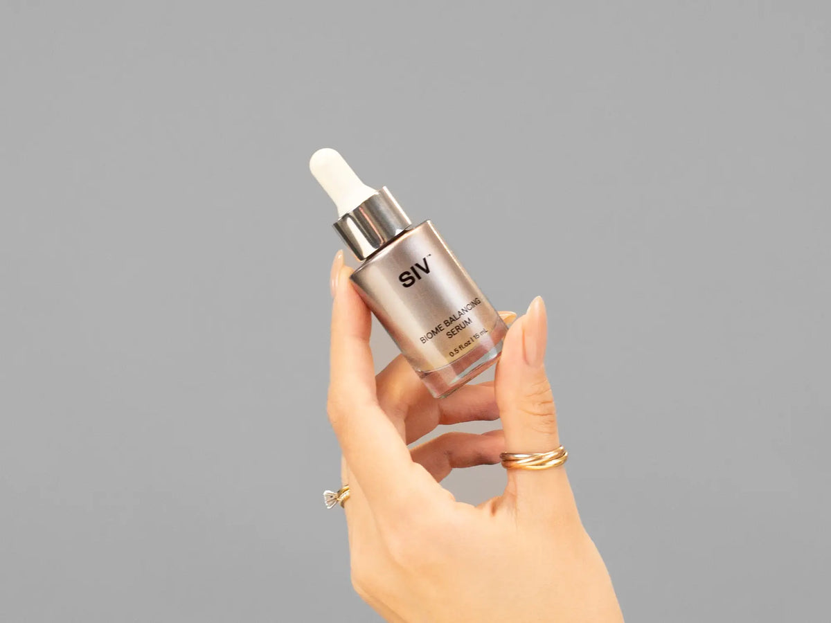 Closeup of Laziza from LAZ Skincare holding up a bottle of SIV Biome Balancing Serum