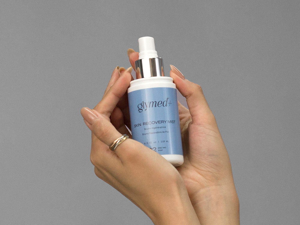 Closeup of Laziza from LAZ Skincare holding up a bottle of GlyMed Skin Recovery Mist