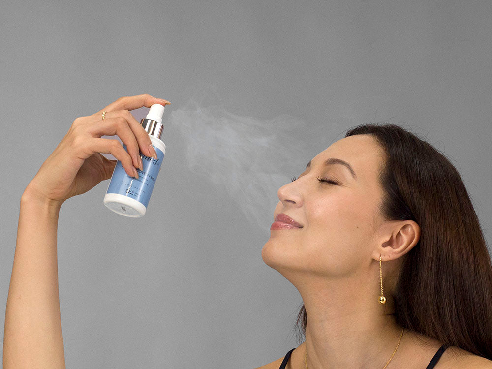 Laziza from LAZ Skincare holding a bottle of GlyMed Skin Recovery Mist up to her face