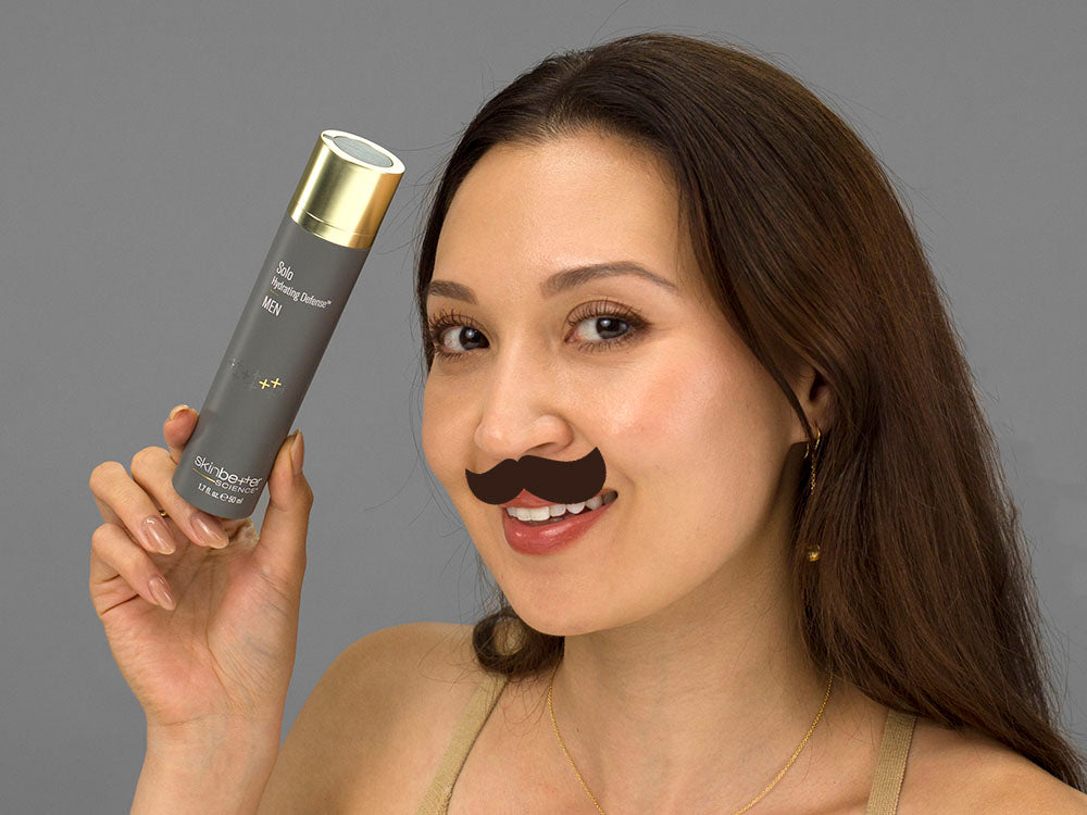 Laziza from LAZ Skincare holding a bottle of SkinBetter Science Solo Hydrating Defense MEN up to her face