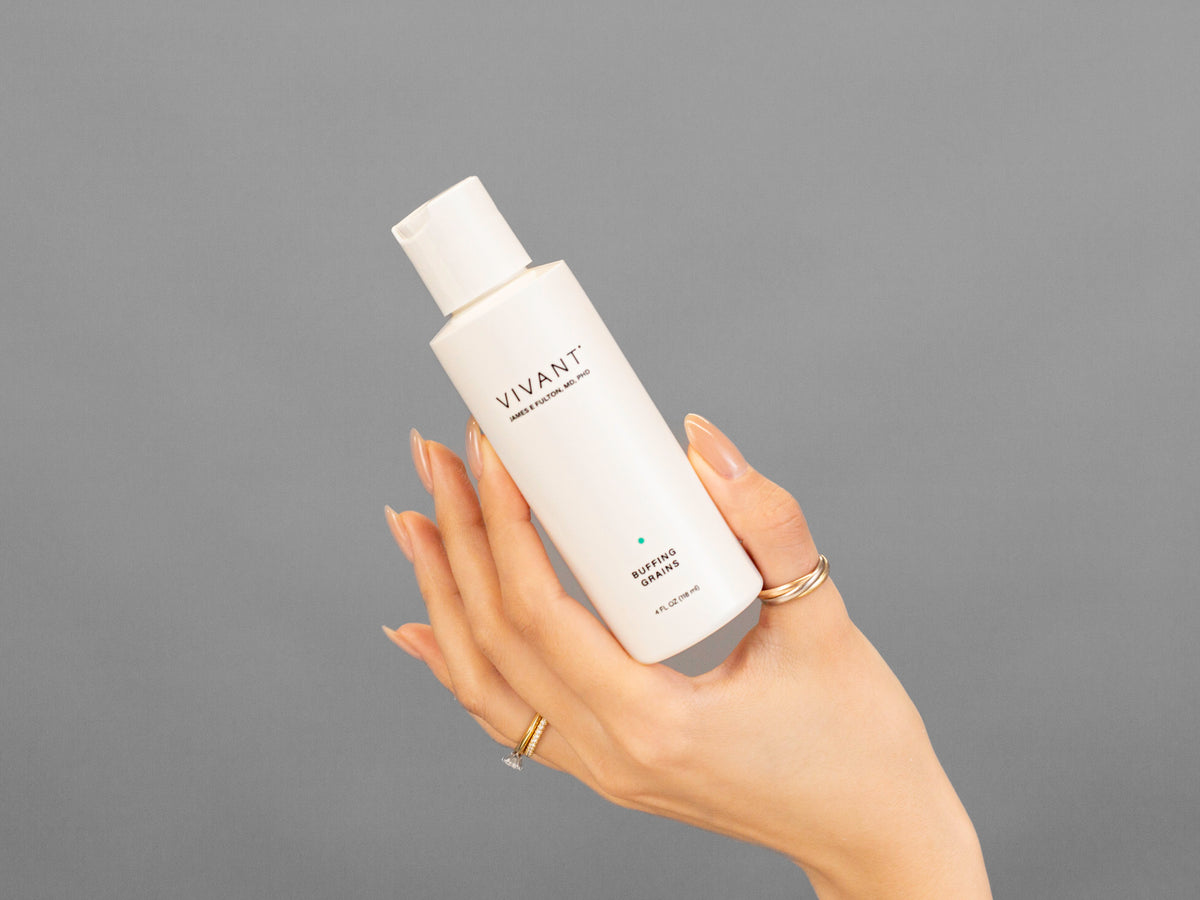 Closeup of Laziza from LAZ Skincare holding up a bottle of Vivant Buffing Grains