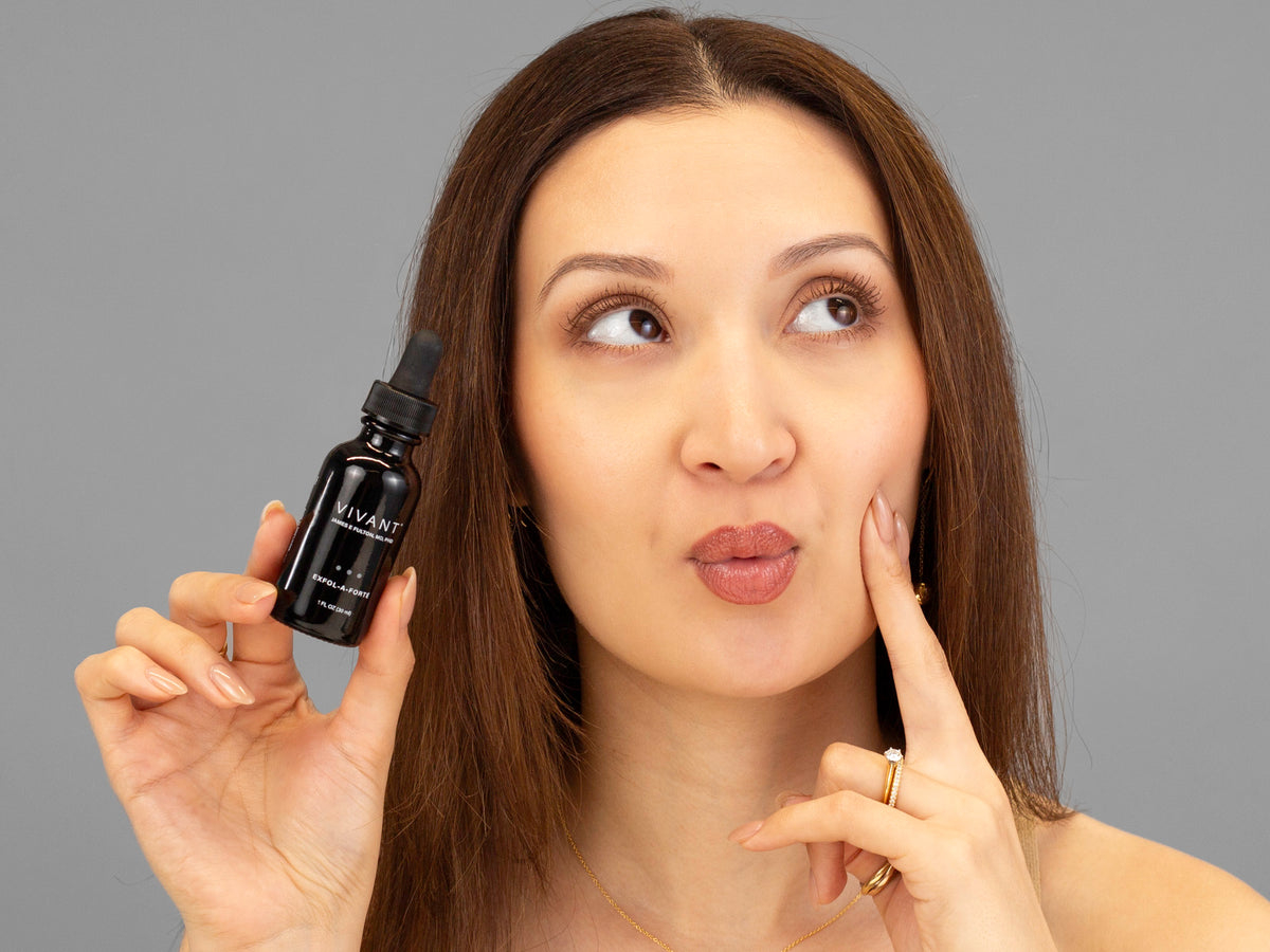 Laziza from LAZ Skincare holding a bottle of Vivant Exfol-A Forté up to her face