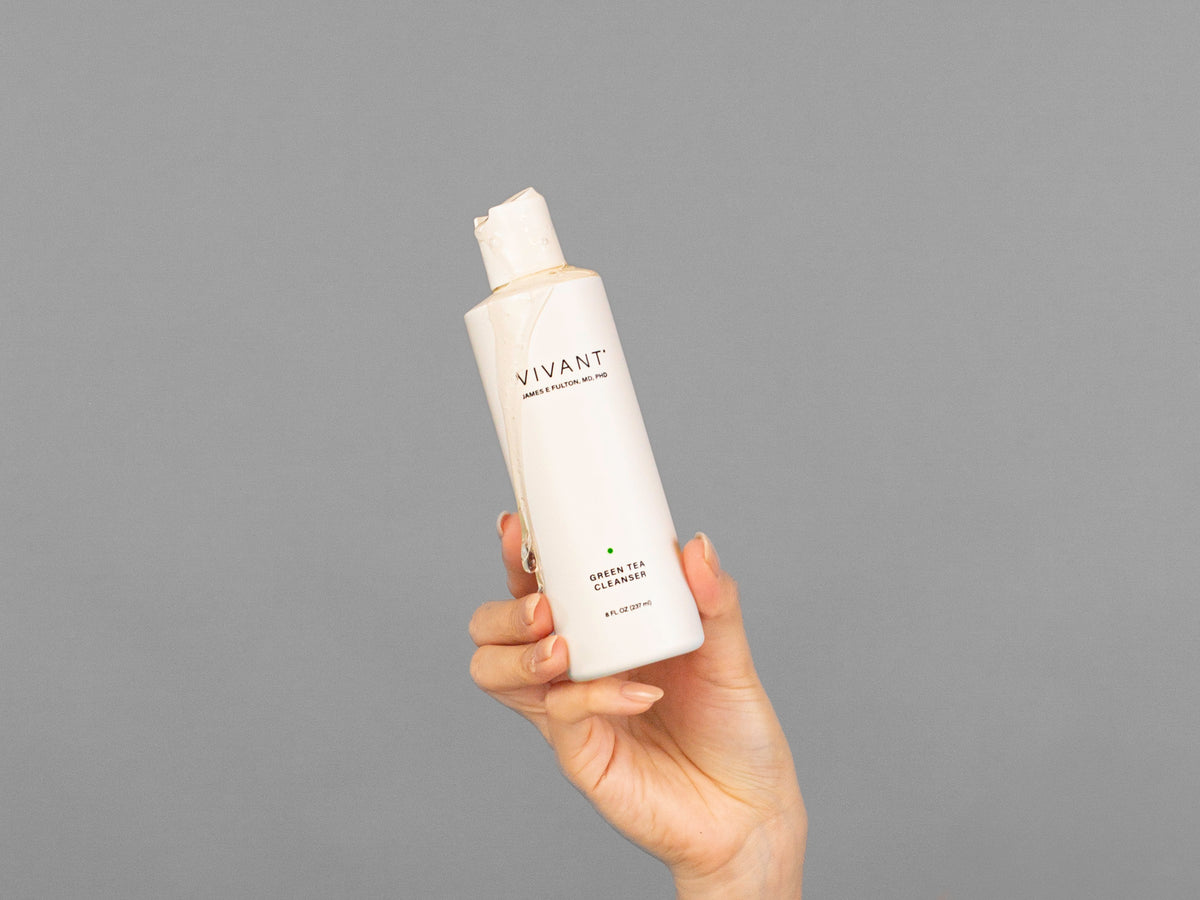 Closeup of Laziza from LAZ Skincare holding up a bottle of Vivant Green Tea Antioxidant Cleanser