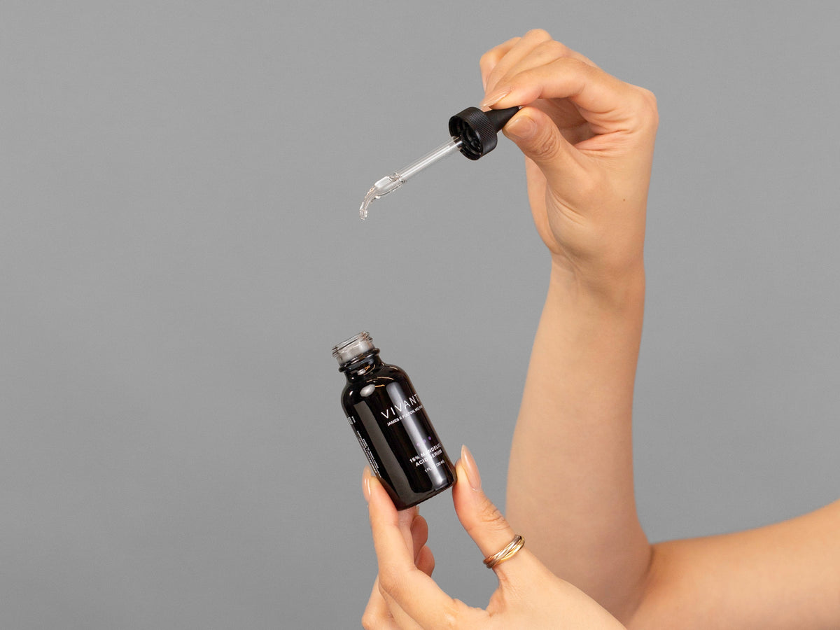 Closeup of Laziza from LAZ Skincare holding up a bottle of Vivant Mandelic Acid Serum