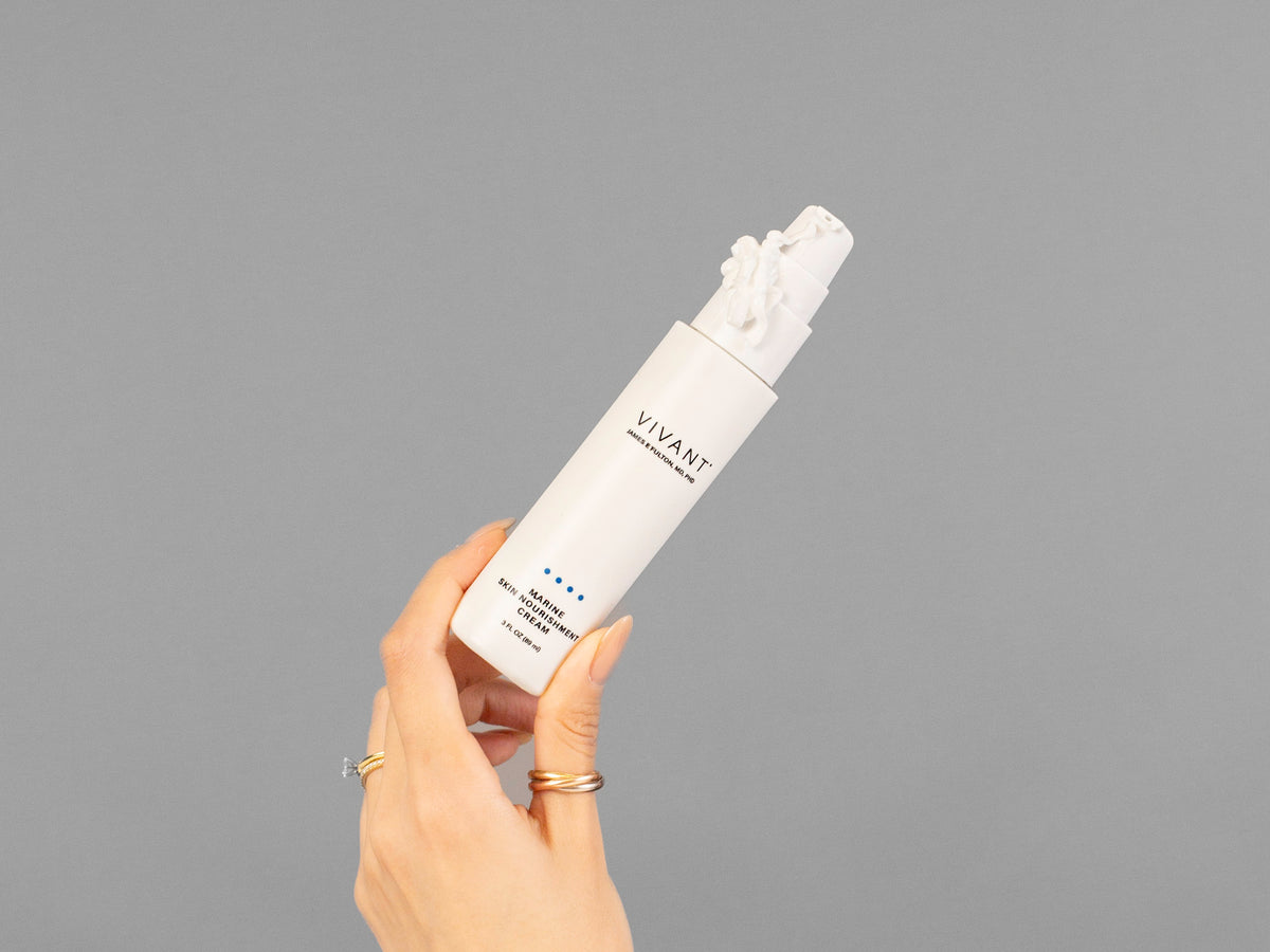 Closeup of Laziza from LAZ Skincare holding up a bottle of Vivant Marine Skin Nourishment Cream