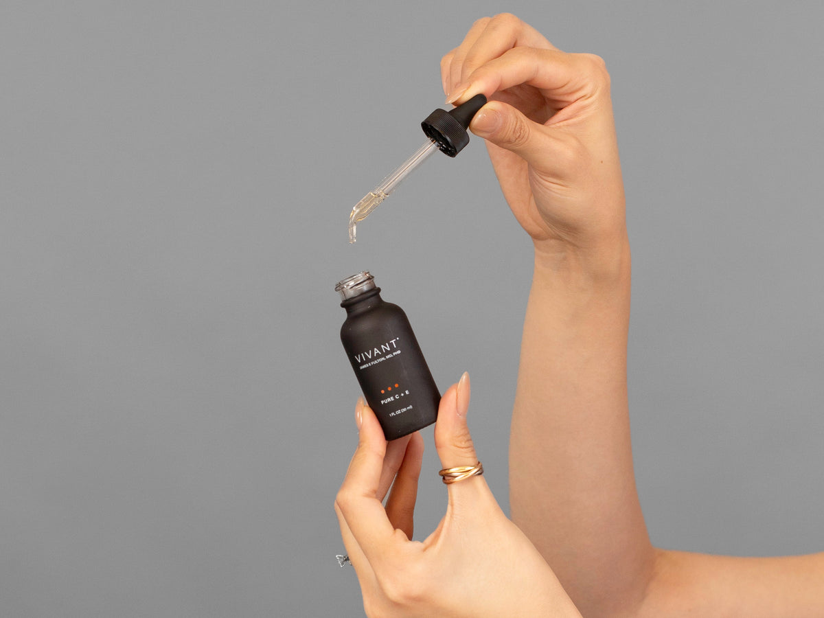 Closeup of Laziza from LAZ Skincare holding up a bottle of Vivant Pure C + E