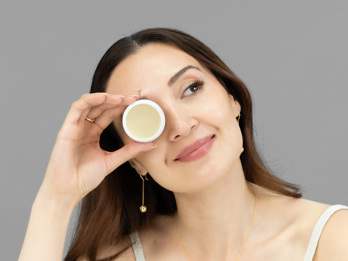 Laziza from LAZ Skincare holding a bottle of Vivant Recovery Ointment up to her face