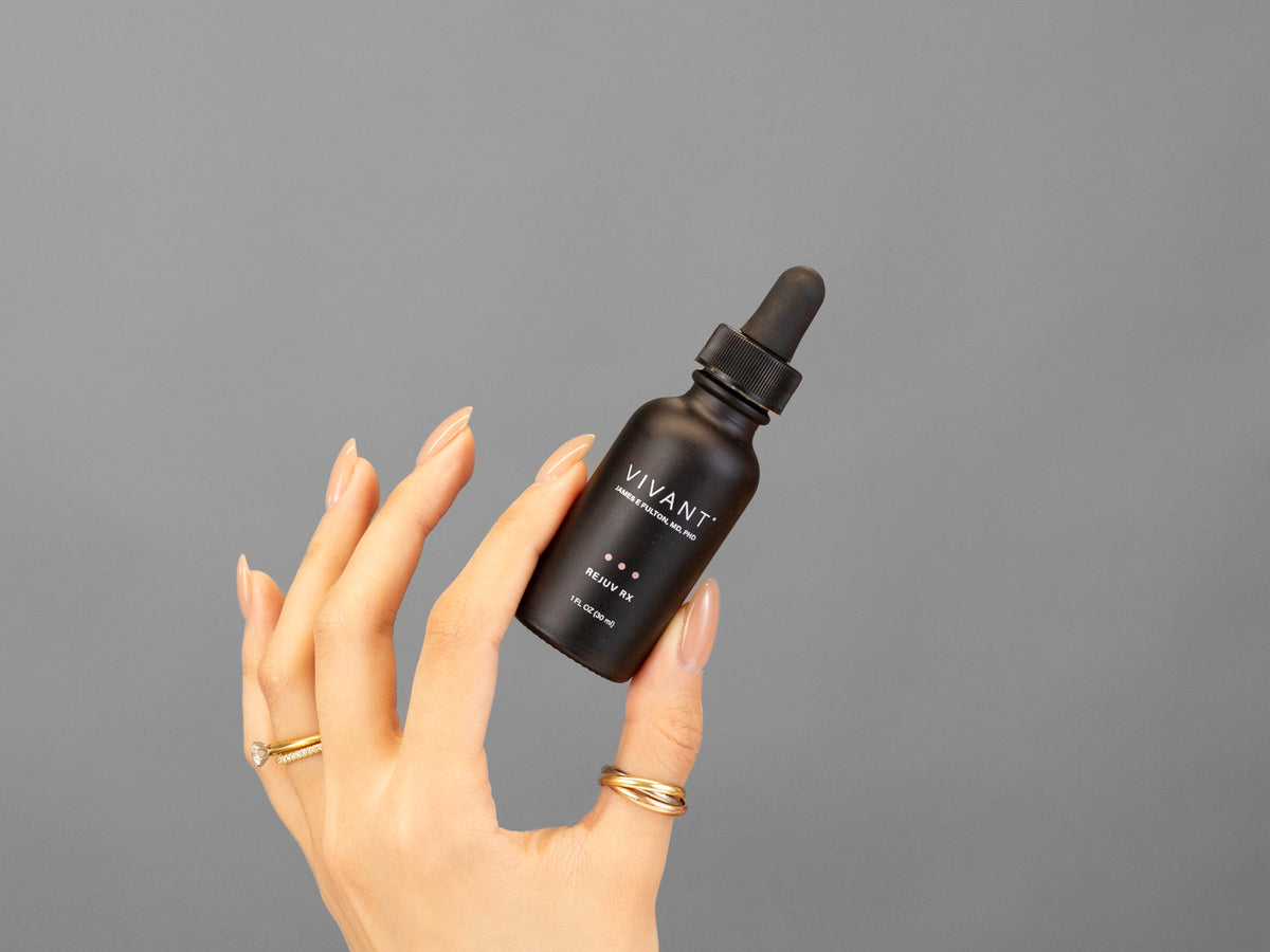 Closeup of Laziza from LAZ Skincare holding up a bottle of Vivant Rejuv Rx