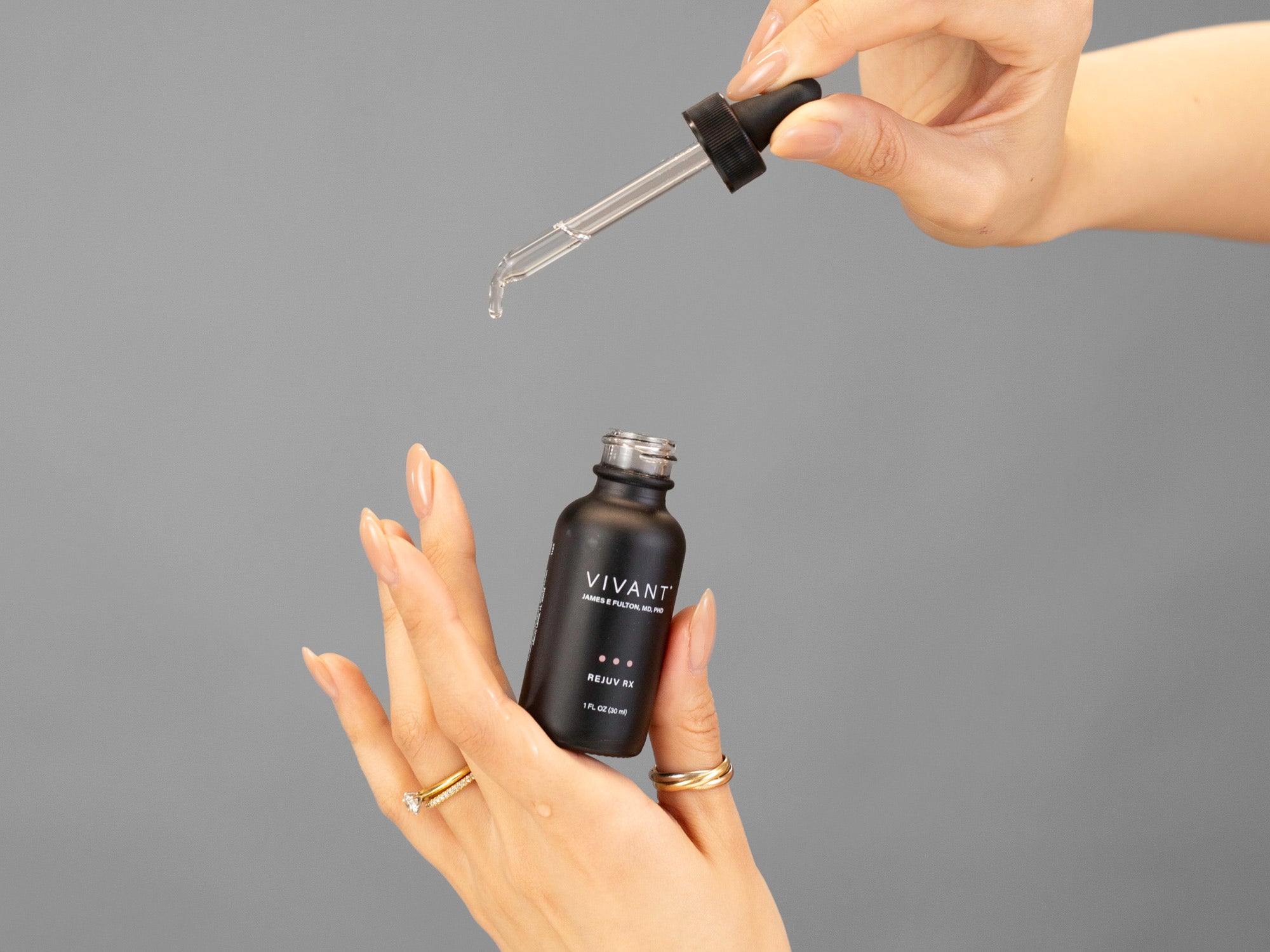 Closeup of Laziza from LAZ Skincare demonstrating the dropper and bottle  of Vivant Rejuv Rx