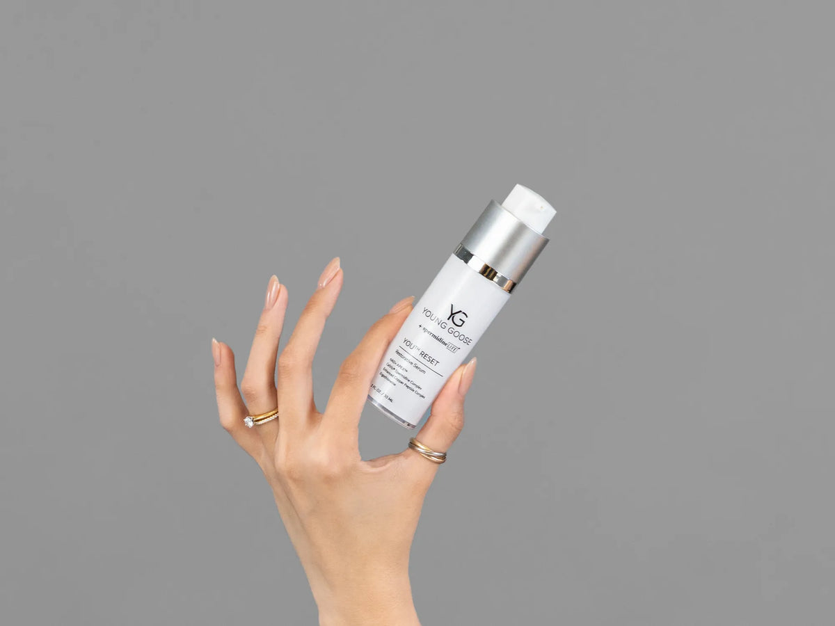 Closeup of Laziza from LAZ Skincare holding up a bottle of Young Goose Youth Reset