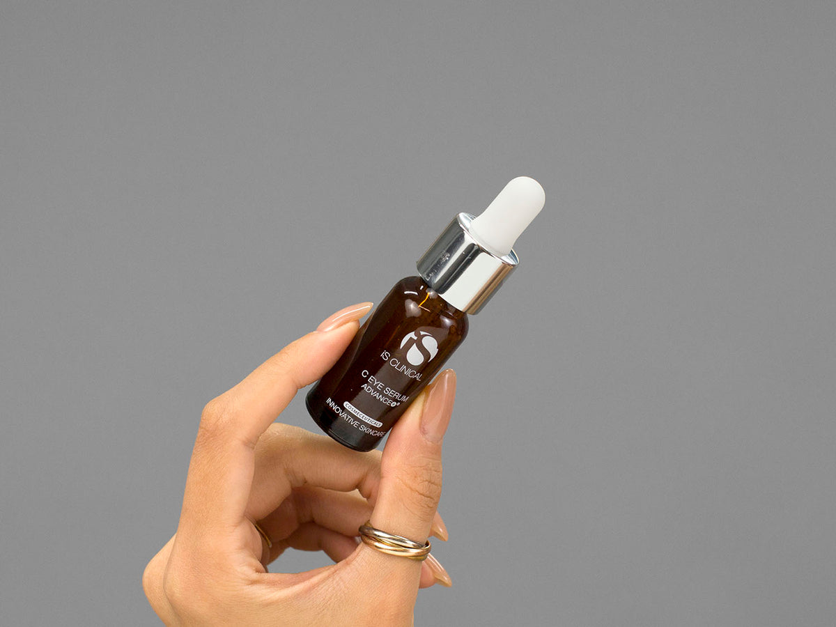 Closeup of Laziza from LAZ Skincare holding up a bottle of iS Clinical C Eye Serum Advance+