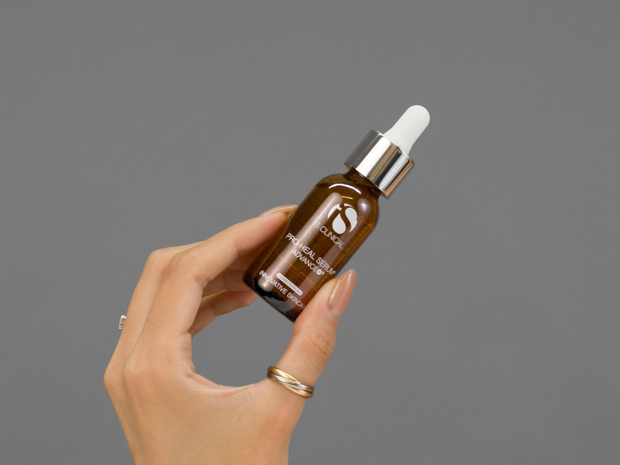 Closeup of Laziza from LAZ Skincare holding a bottle of iS Clinical Pro-Heal Serum Advance in her hand