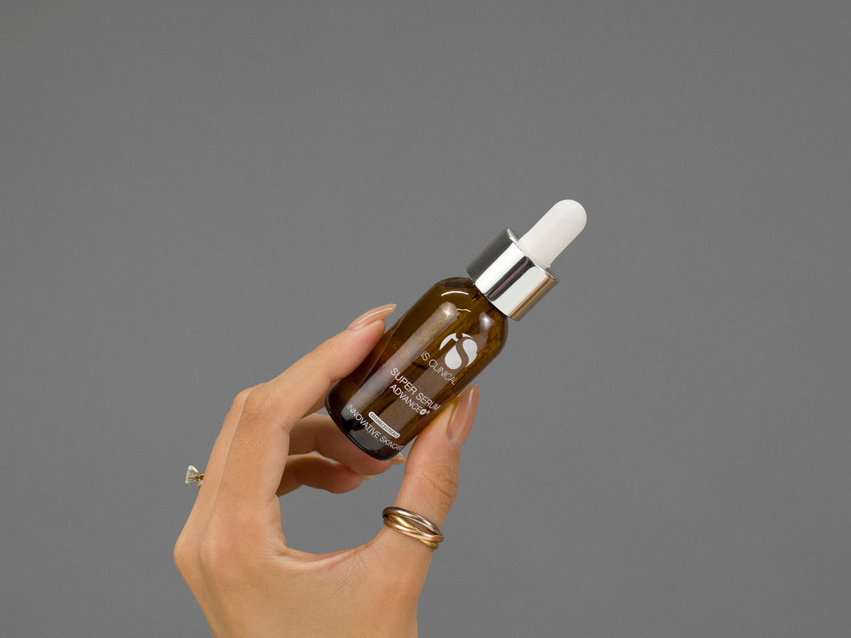 Closeup of Laziza from LAZ Skincare holding up a bottle of iS Clinical Super Serum Advance+