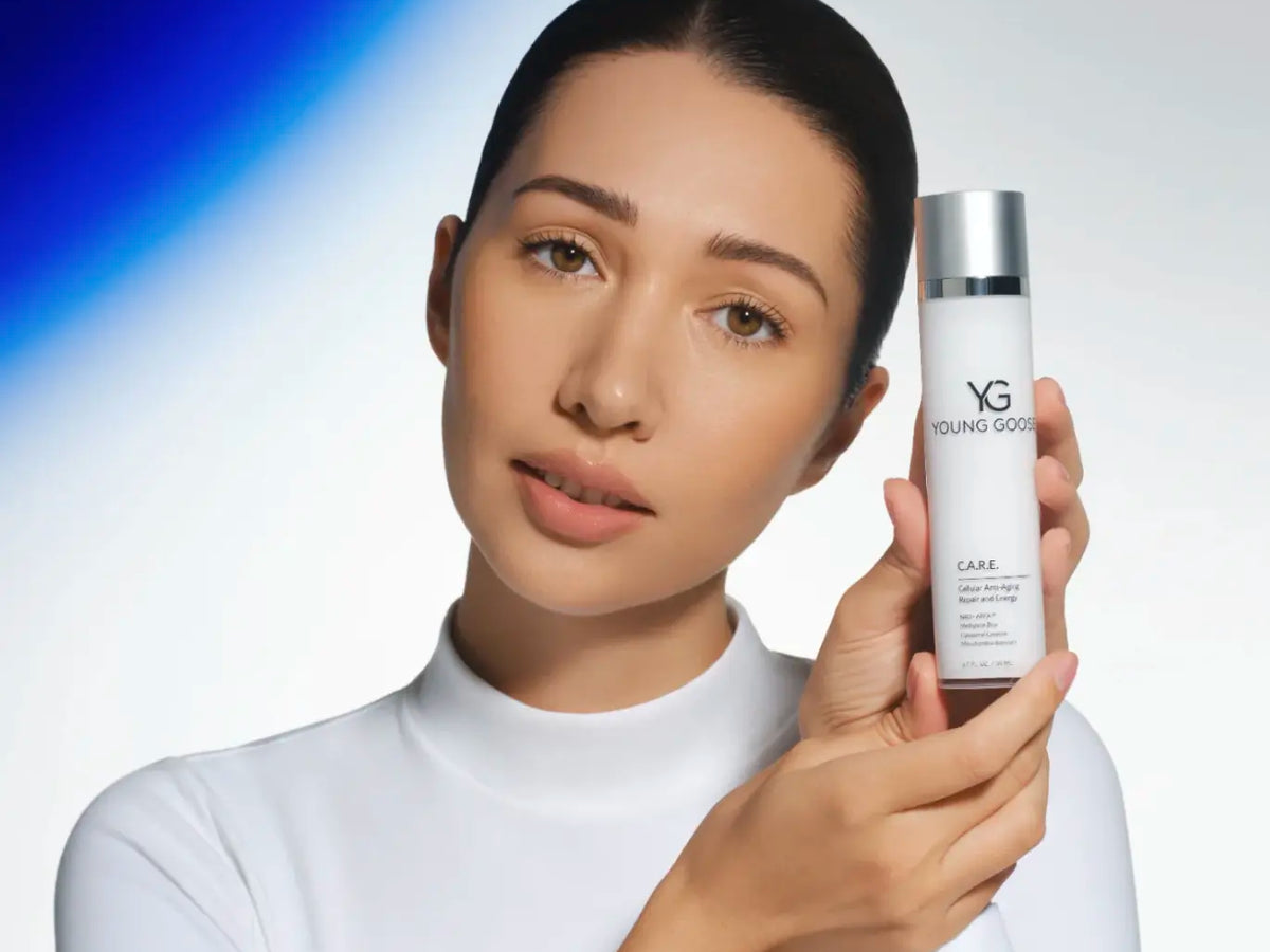 Laziza from LAZ Skincare holding a bottle of Young Goose C.A.R.E. up to her face