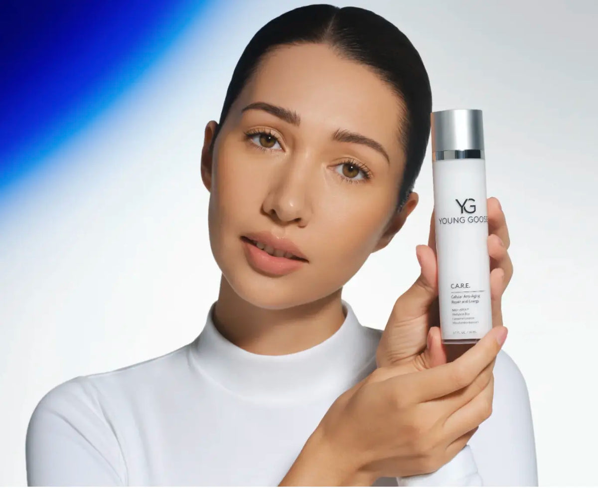 Laziza from LAZ Skincare holding a bottle of Young Goose C.A.R.E. up to her face